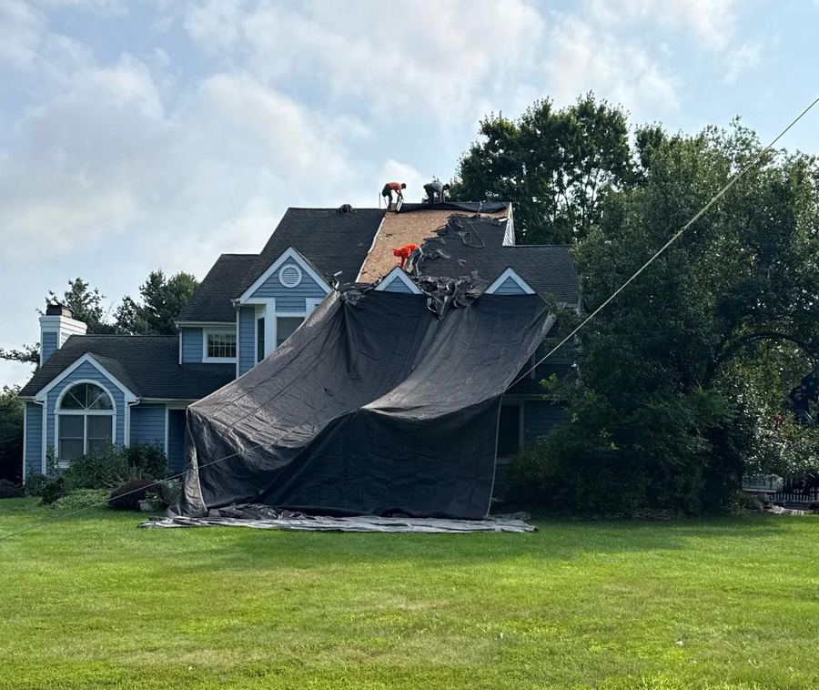 Roof before replacement, old shingles torn off and tarped